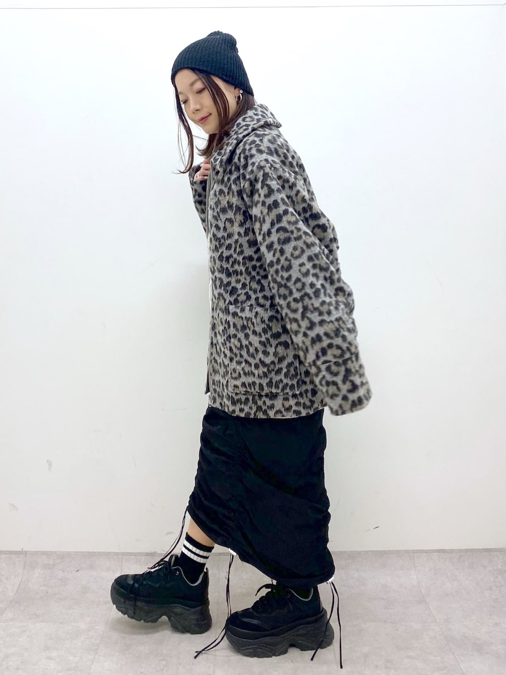 ベージュ系のスウェット、ブラック系のワンピース、ブラック系のスニーカーを着用したレディースの冬コーディネートの5枚目の写真