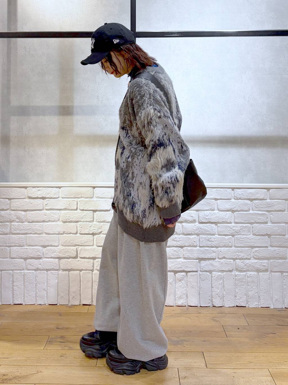 ブラック系のブーツ、グレー系のスウェットパンツ、ブラック系のボストンバッグを着用したレディースの冬コーディネートの5枚目の写真