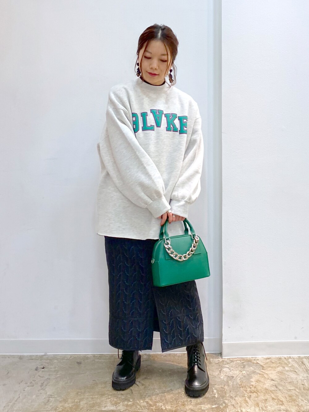 ブラック系のブーツ、ブラック系のニット/セーター、ブラック系のスカートを着用したレディースの冬コーディネートの2枚目の写真