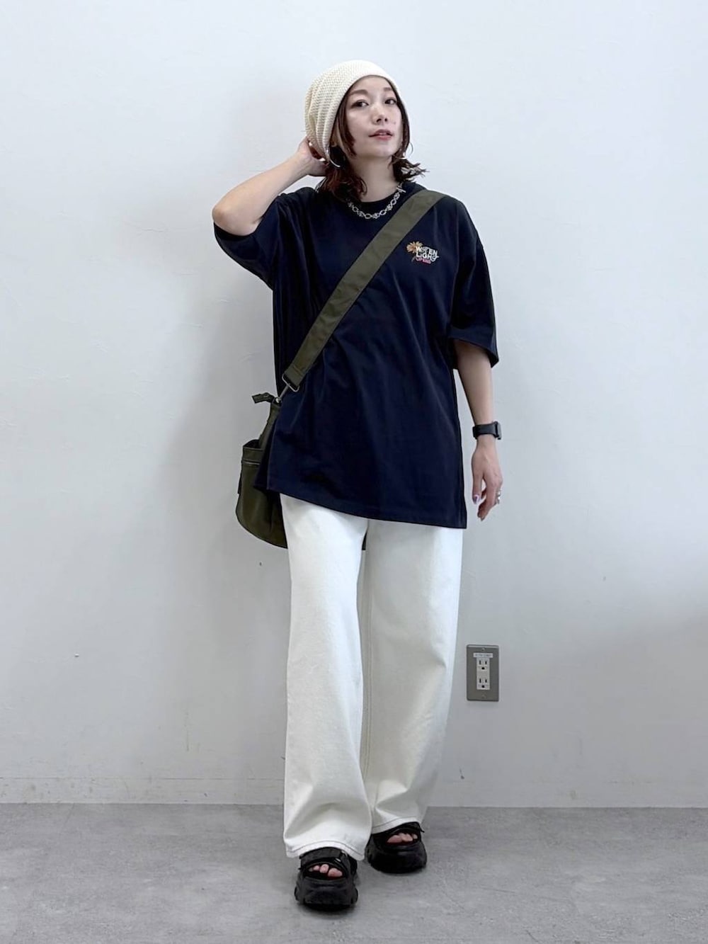 グリーン系のボストンバッグ、ホワイト系のスラックス、ブルー系のTシャツ/カットソーを着用したレディースの春コーディネートの9枚目の写真