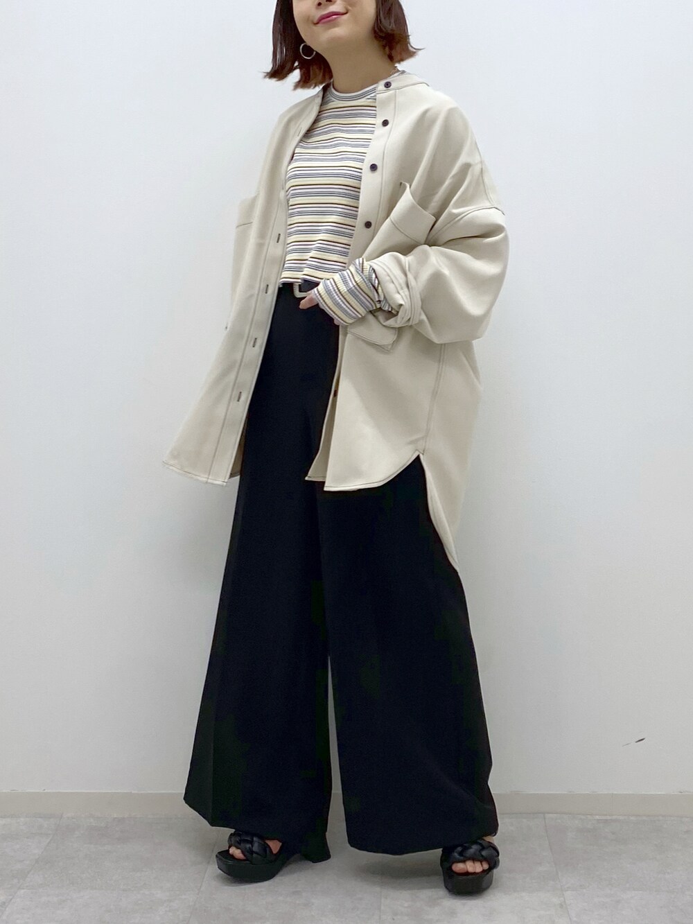 ホワイト系のシャツ/ブラウス、ホワイト系のTシャツ/カットソー、ブラック系のスラックスを着用したレディースの春コーディネートの5枚目の写真