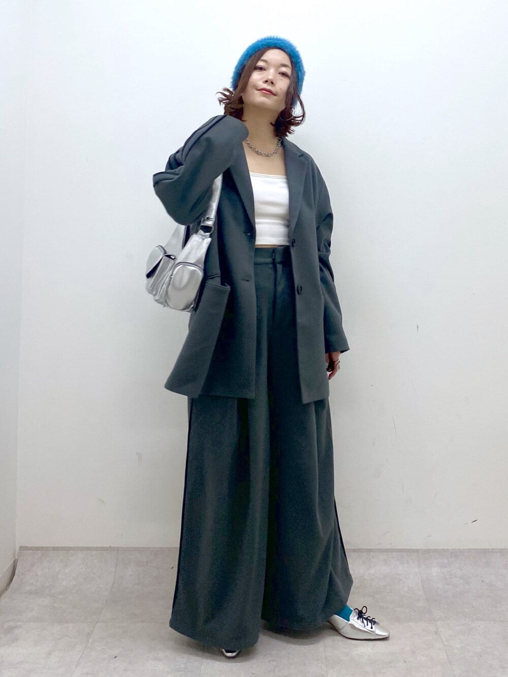 グレー系のスラックス、シルバー系のパンプス、シルバー系のショルダーバッグを着用したレディースの秋コーディネートの4枚目の写真