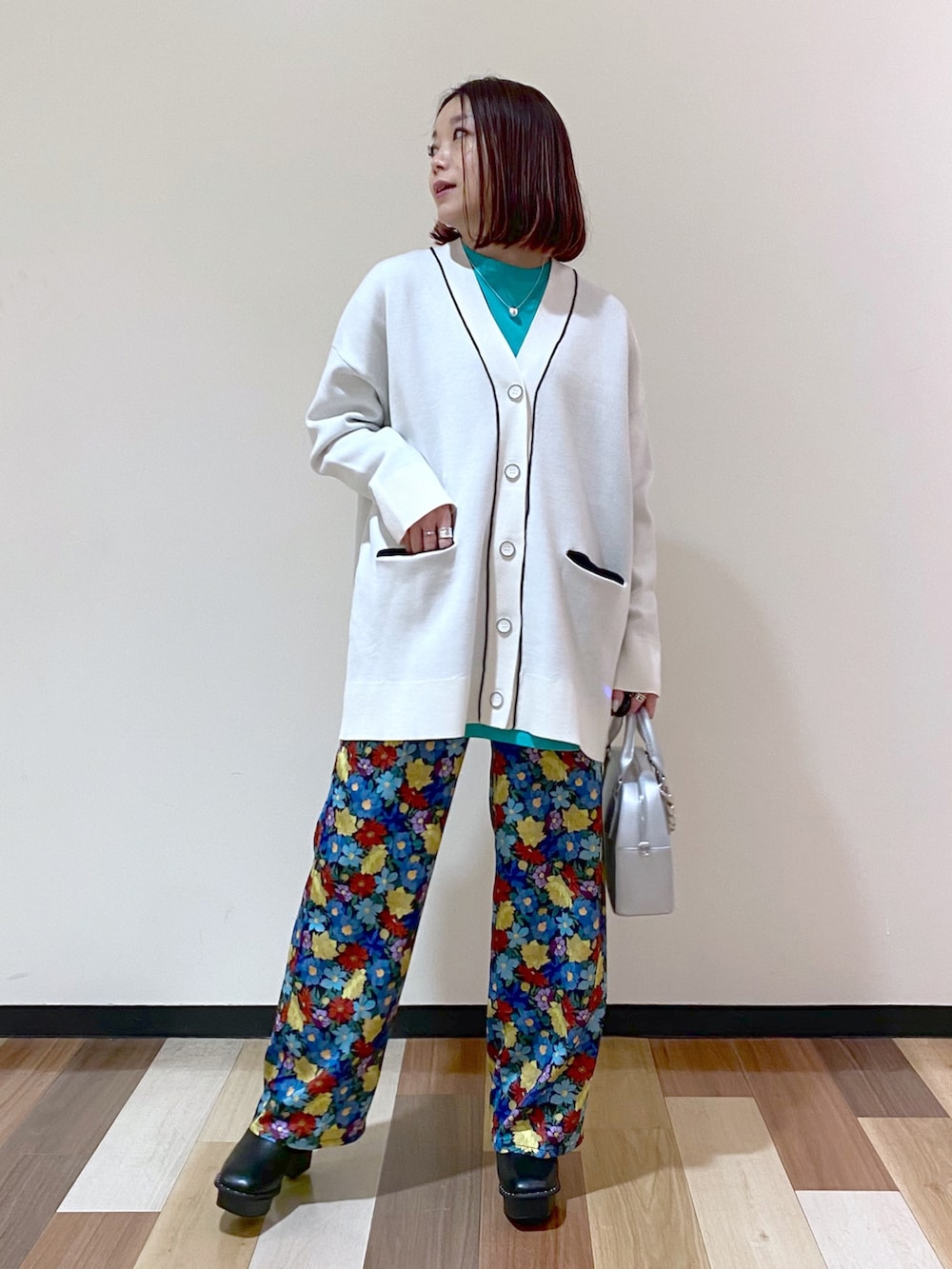 ブラック系のブーツ、シルバー系のショルダーバッグ、ホワイト系のカーディガン/ボレロを着用したレディースの冬コーディネートの2枚目の写真