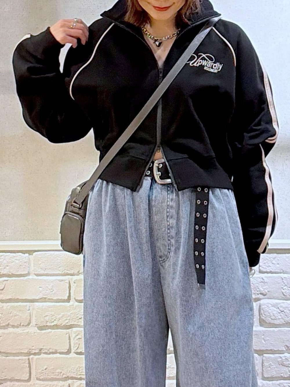 ブラック系のスニーカー、グレー系のショルダーバッグ、ブルー系のデニムパンツを着用したレディースの春コーディネートの2枚目の写真