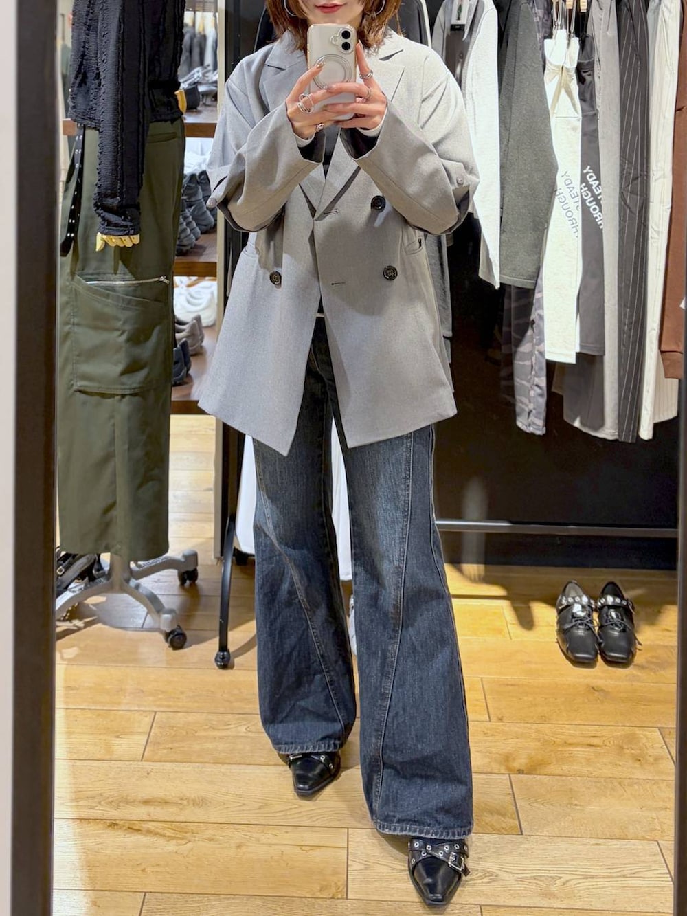 ブルー系のデニムパンツ、グレー系のテーラードジャケット、ブラック系のTシャツ/カットソーを着用したレディースの春コーディネートの3枚目の写真