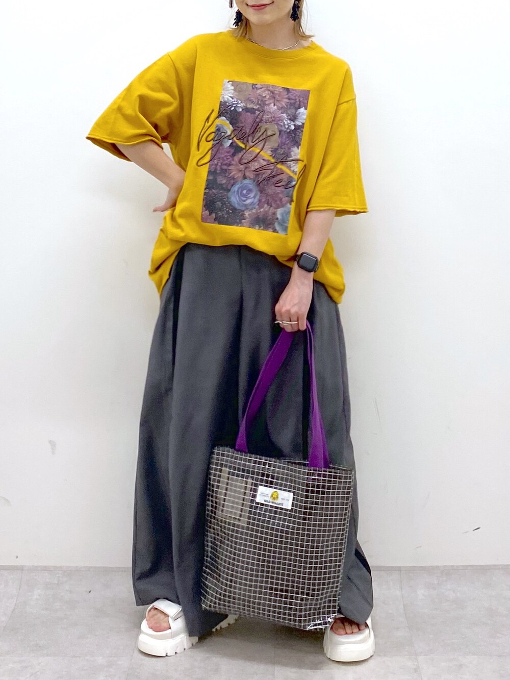 イエロー系のTシャツ/カットソー、グレー系のスラックス、グレー系のトートバッグを着用したレディースの夏コーディネートの7枚目の写真