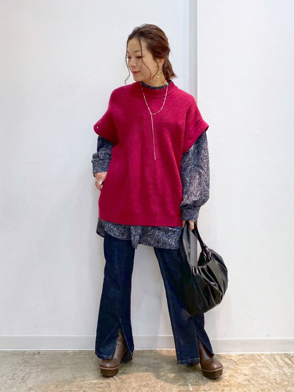 ピンク系のニット/セーター、ブラック系のTシャツ/カットソー、ブラック系のハンドバッグを着用したレディースの秋コーディネートの2枚目の写真