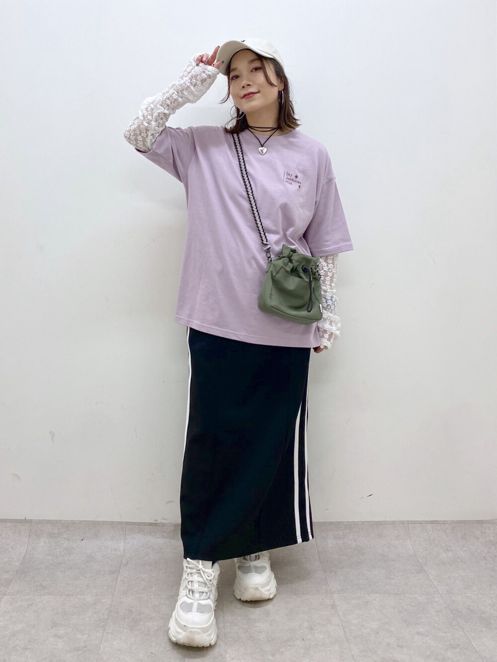 ブラック系のスカート、ホワイト系のスニーカー、ホワイト系のTシャツ/カットソーを着用したレディースの夏コーディネートの4枚目の写真