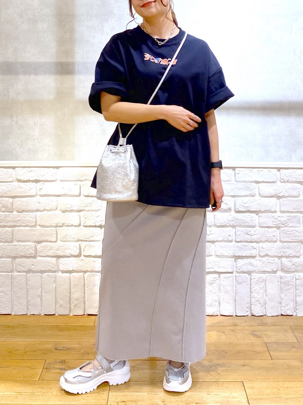 ブルー系のTシャツ/カットソー、グレー系のスカート、グレー系のスニーカーを着用したレディースの春コーディネートの3枚目の写真