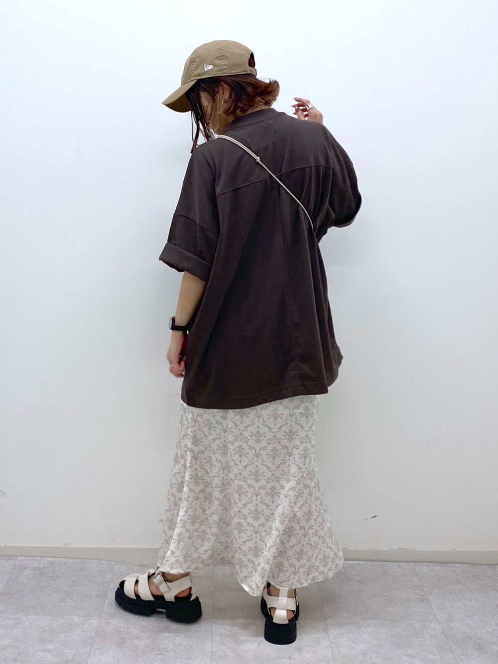 ブラウン系のTシャツ/カットソー、グレー系のスカート、ベージュ系のショルダーバッグを着用したレディースの夏コーディネートの3枚目の写真