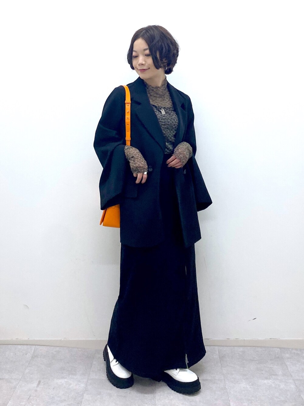 ブラック系のスカート、ホワイト系のブーツ、ブラック系のジャケット/アウターを着用したレディースの秋コーディネートの2枚目の写真