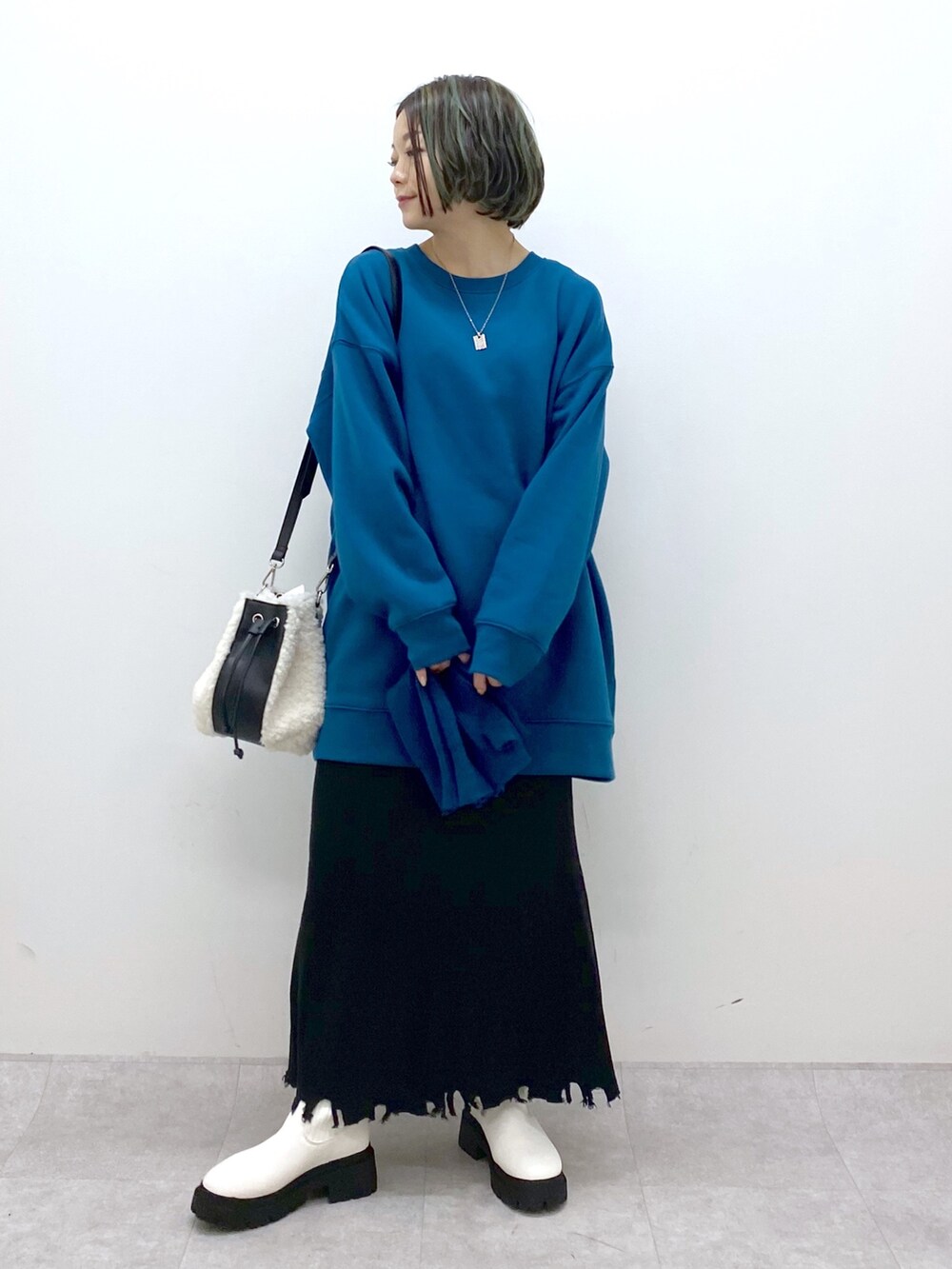 ホワイト系のバッグ、ホワイト系のシューズ、ブラック系のスカートを着用したレディースの冬コーディネートの5枚目の写真