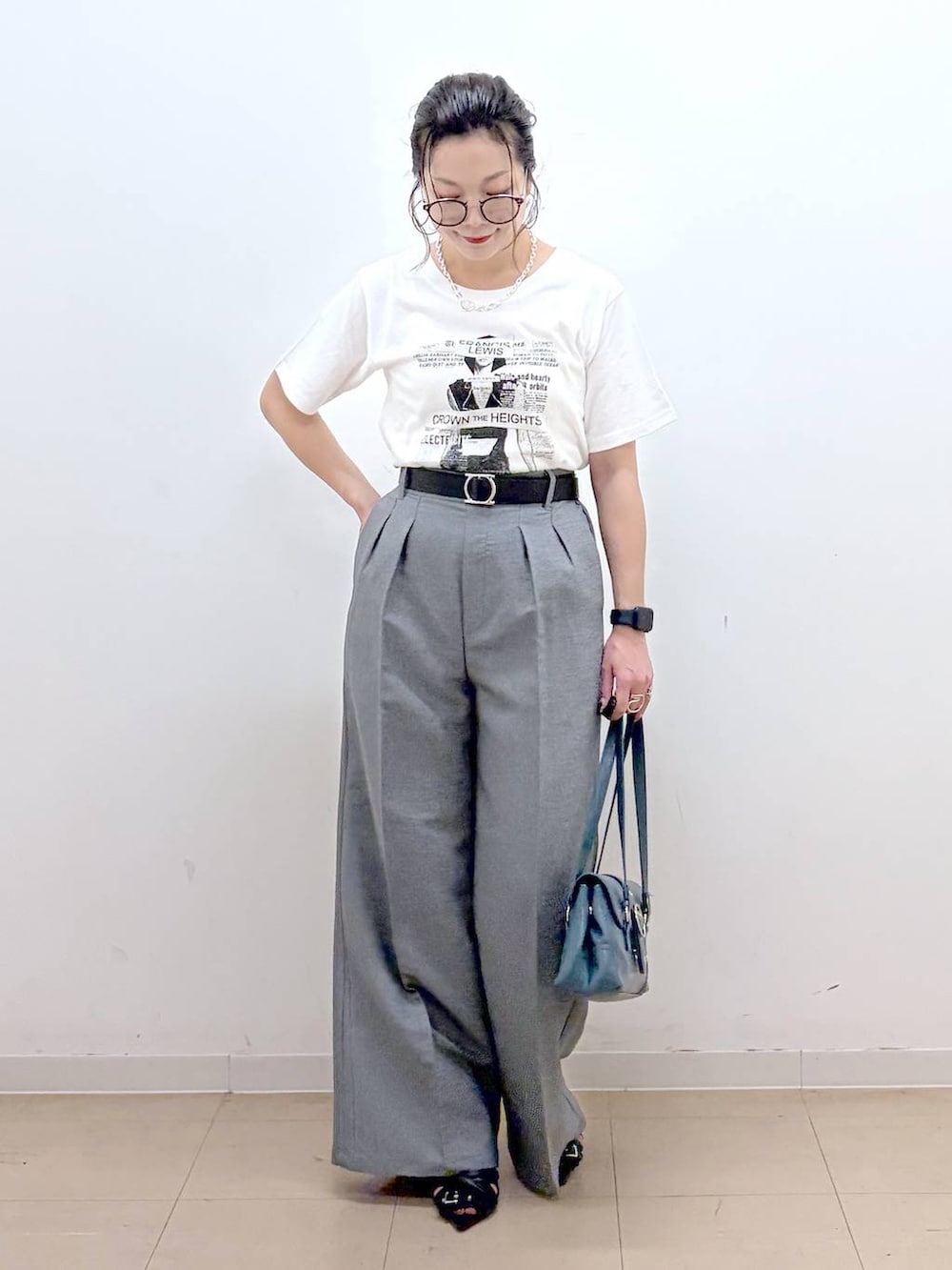 ホワイト系のTシャツ/カットソー、グレー系のスラックス、ブラック系のサンダルを着用したレディースの夏コーディネートの4枚目の写真