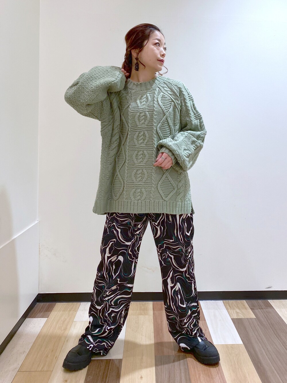 グリーン系のニット/セーター、ブラック系のその他パンツ、ブラック系のブーツを着用したレディースの冬コーディネートの2枚目の写真