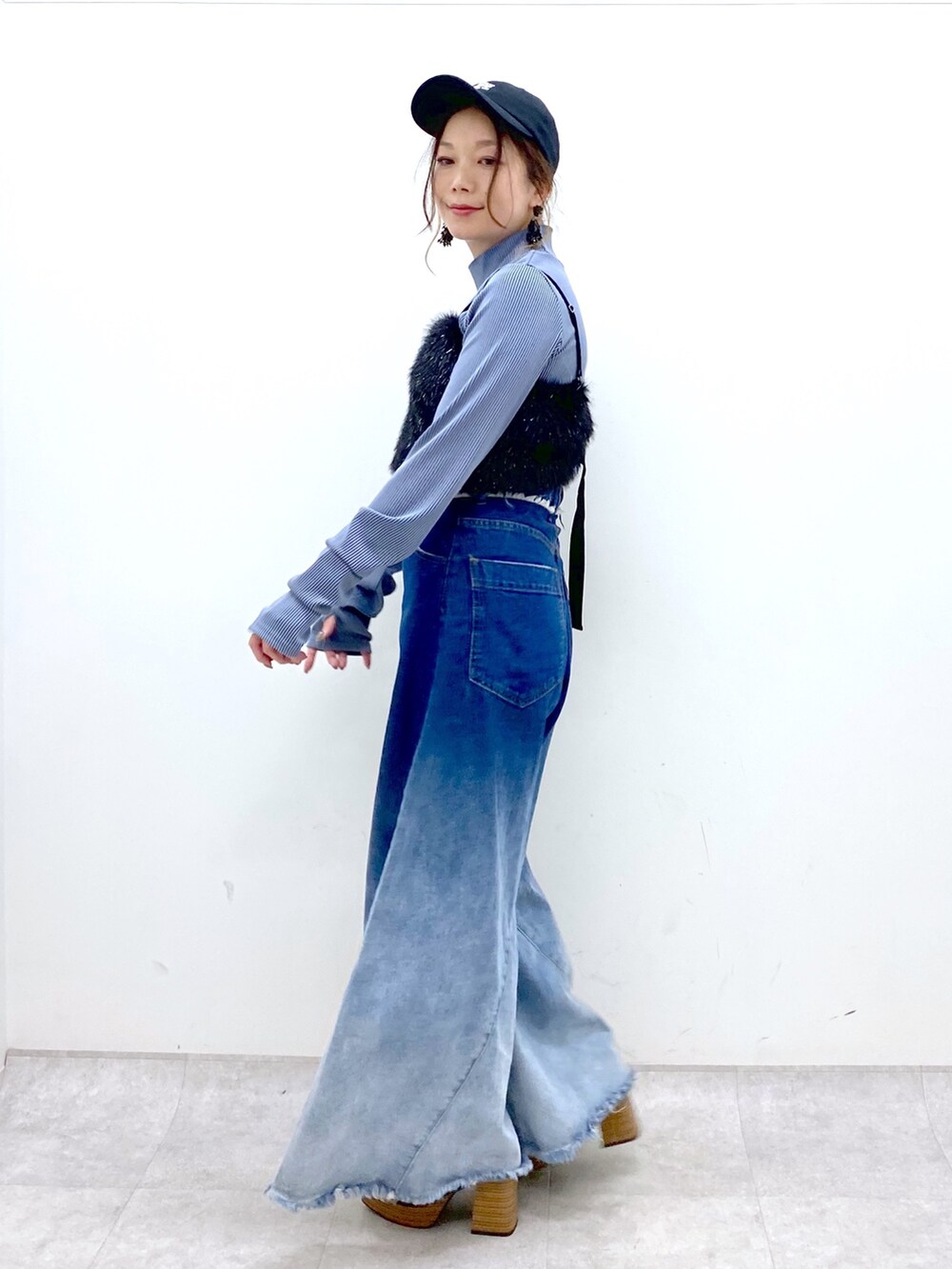 ブルー系のデニムパンツ、ブラック系のベスト、ブルー系のTシャツ/カットソーを着用したレディースの秋コーディネートの3枚目の写真