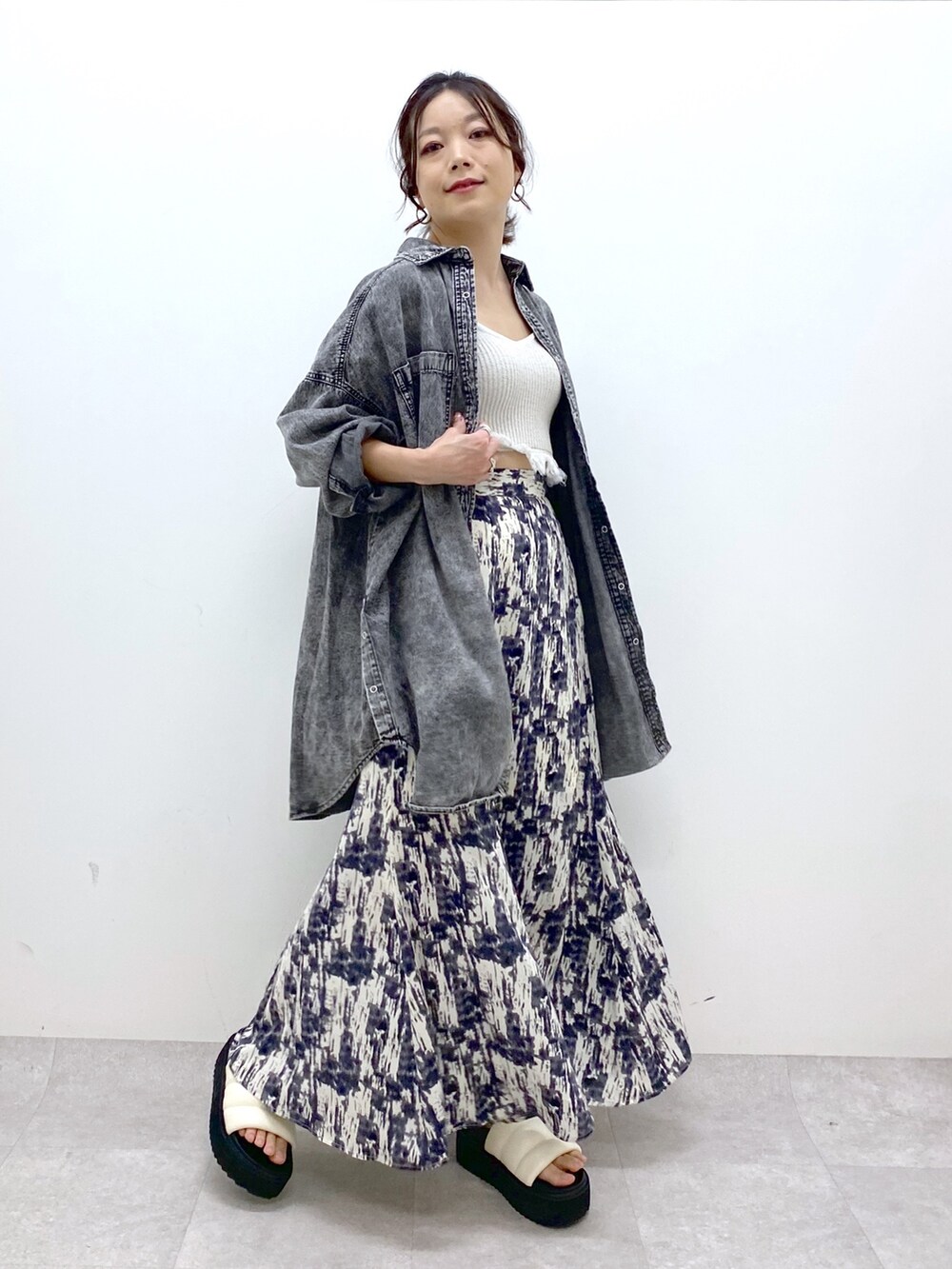 ブラック系のトップス、ブラック系のスカート、ホワイト系のトップスを着用したレディースの春コーディネートの5枚目の写真