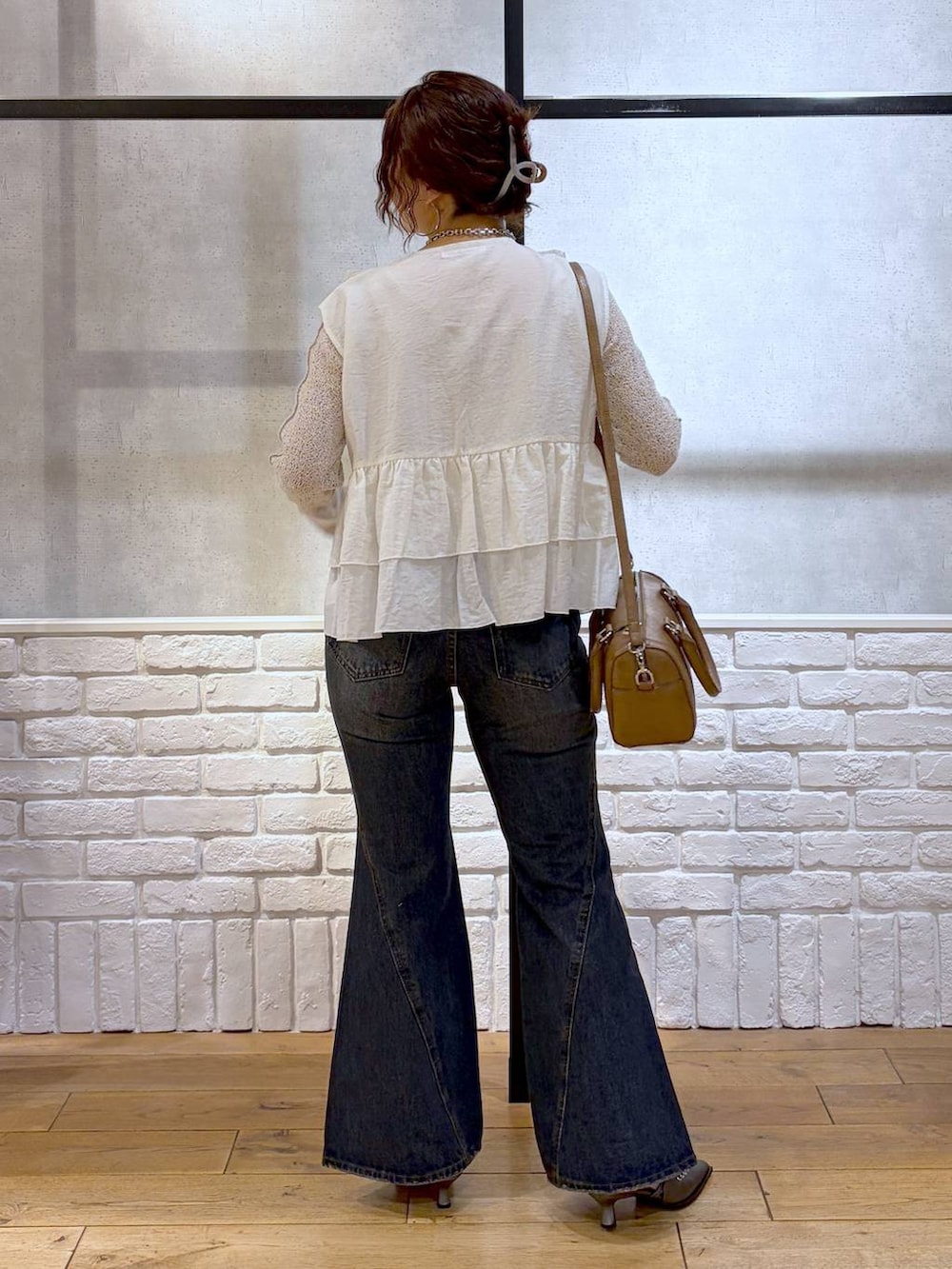 ブルー系のデニムパンツ、ブラウン系のボストンバッグ、ブラウン系のサンダルを着用したレディースの春コーディネートの6枚目の写真