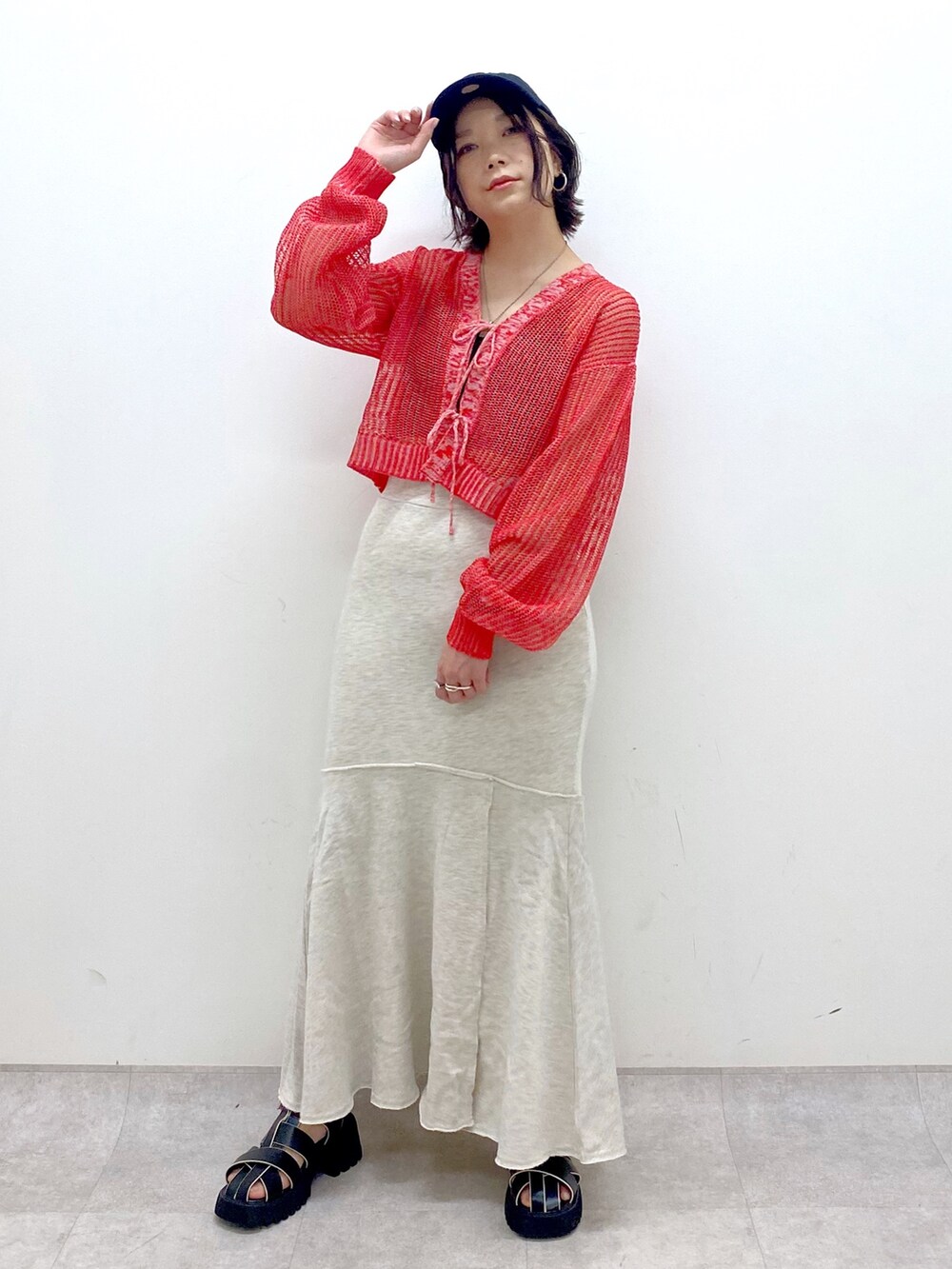 ベージュ系のスカート、レッド系のカーディガン/ボレロ、ブラック系のサンダルを着用したレディースの春コーディネートの5枚目の写真