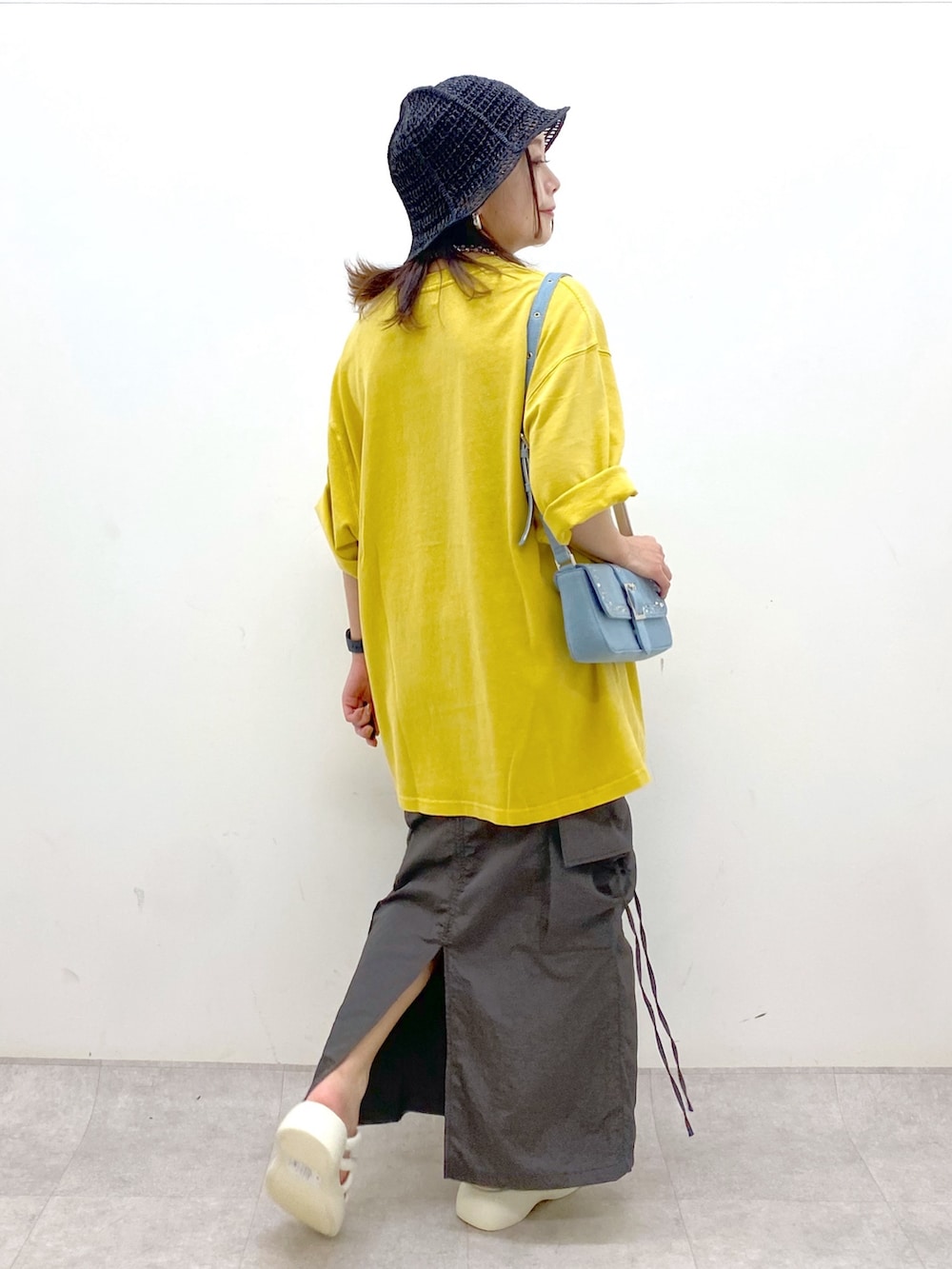 グレー系のスカート、ホワイト系のサンダル、ブルー系のハンドバッグを着用したレディースの春コーディネートの7枚目の写真