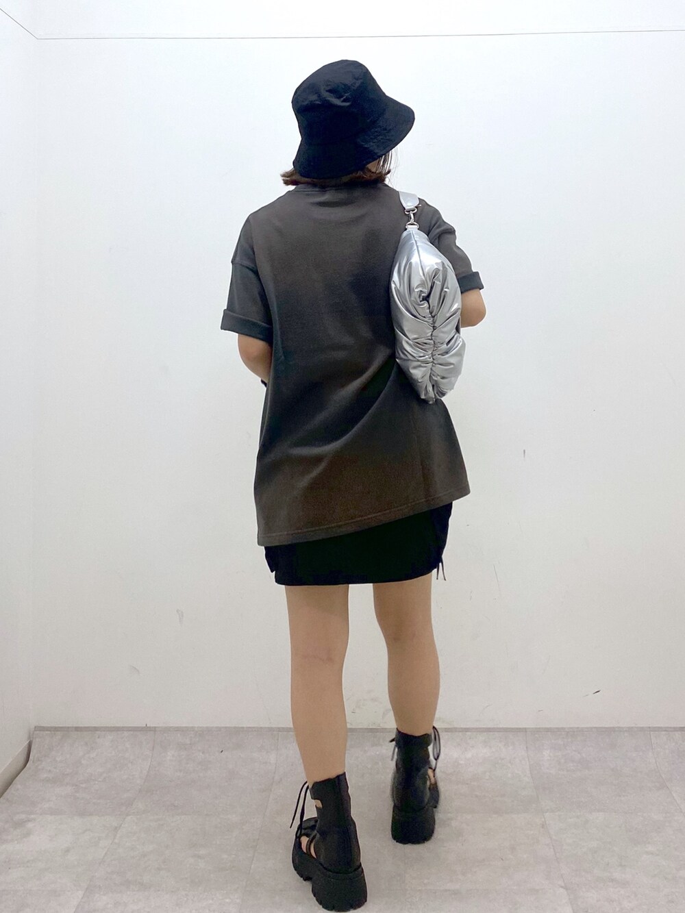 グレー系のTシャツ/カットソー、ブラック系のスカート、ブラック系のサンダルを着用したレディースの夏コーディネートの6枚目の写真