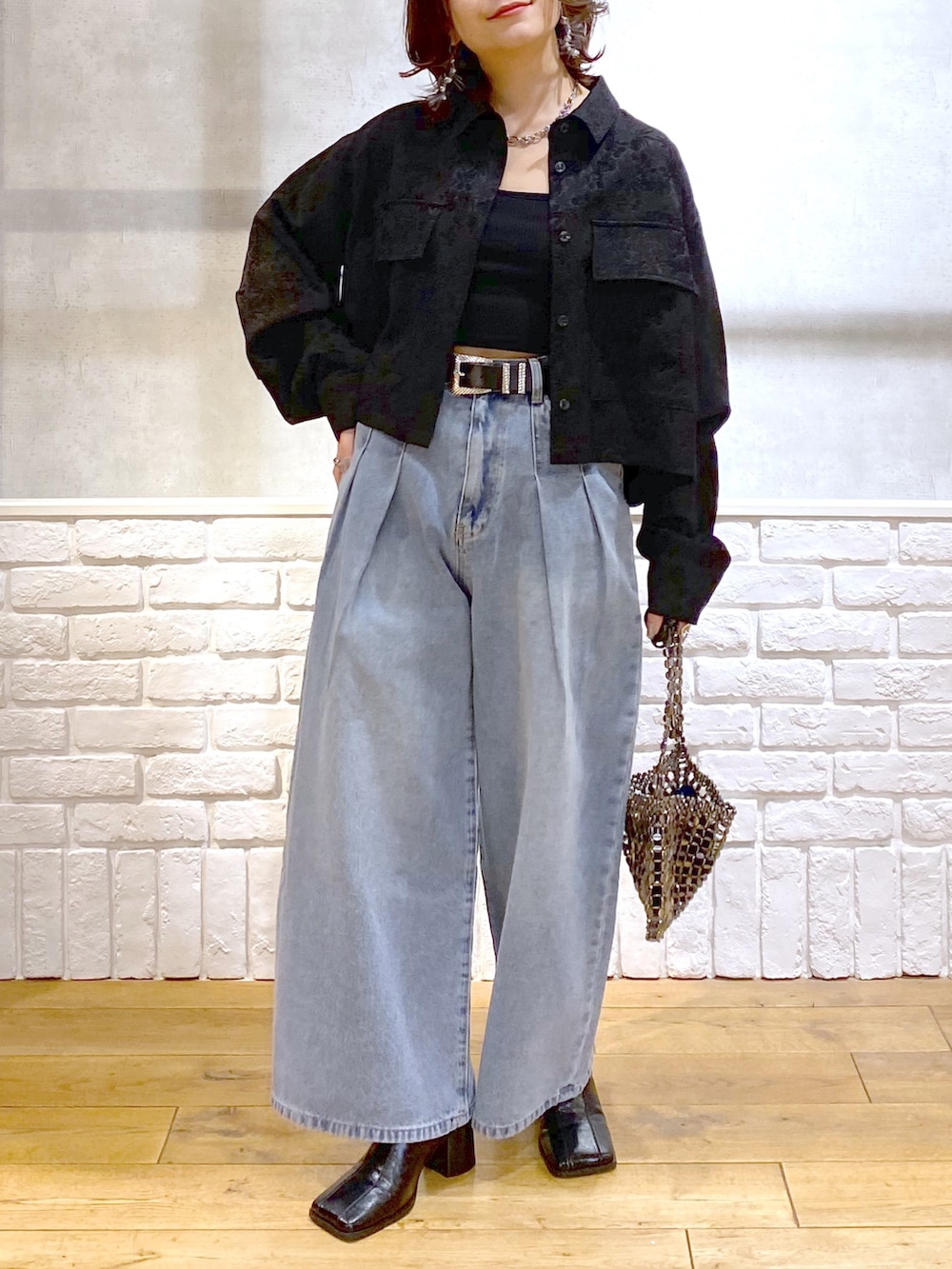 ブラック系のシャツ/ブラウス、ブルー系のデニムパンツ、ブルー系のショルダーバッグを着用したレディースの冬コーディネートの3枚目の写真