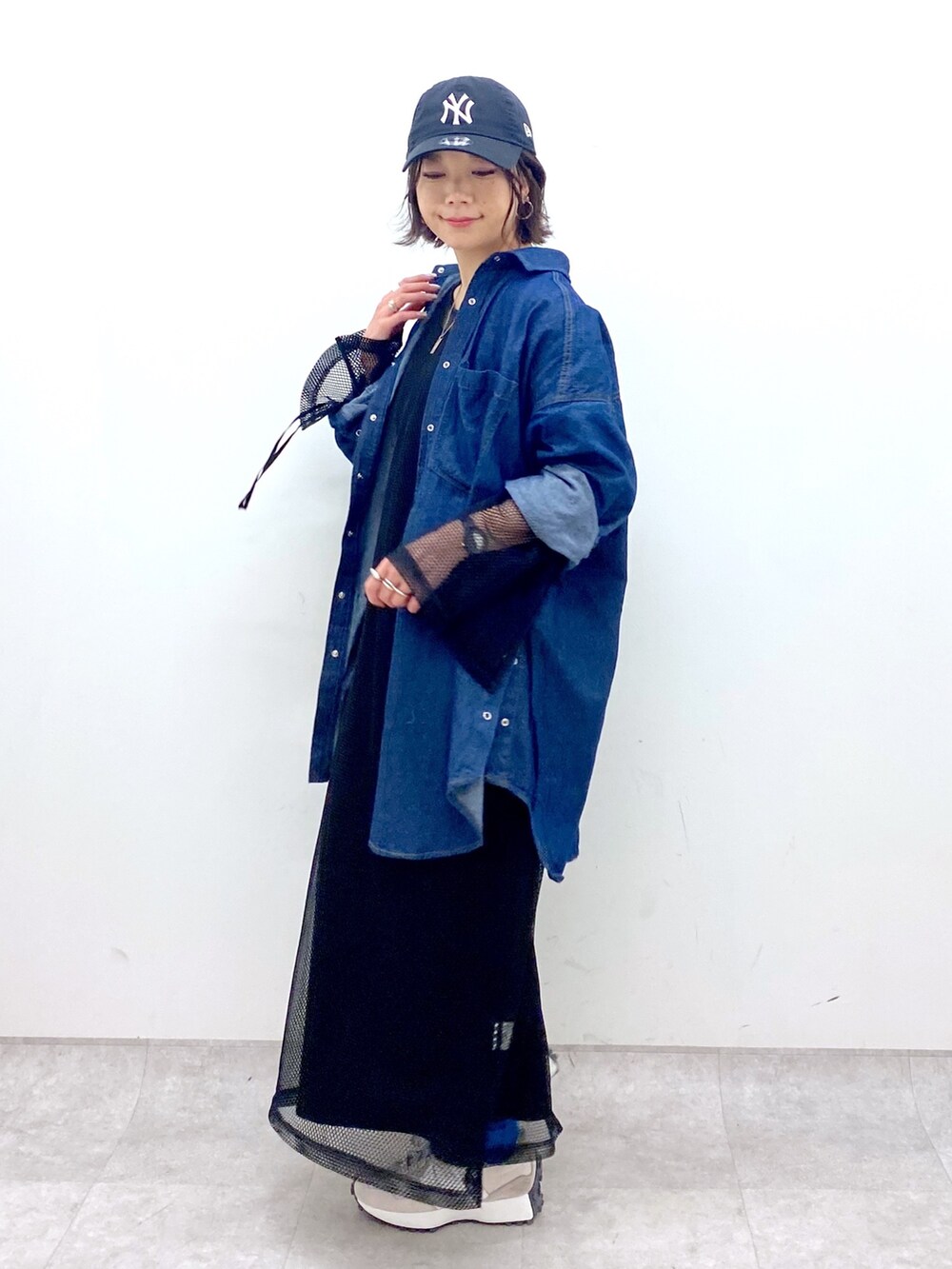 ブルー系のトップス、ブラック系のワンピース/ドレス、ベージュ系のスニーカーを着用したレディースの春コーディネートの3枚目の写真