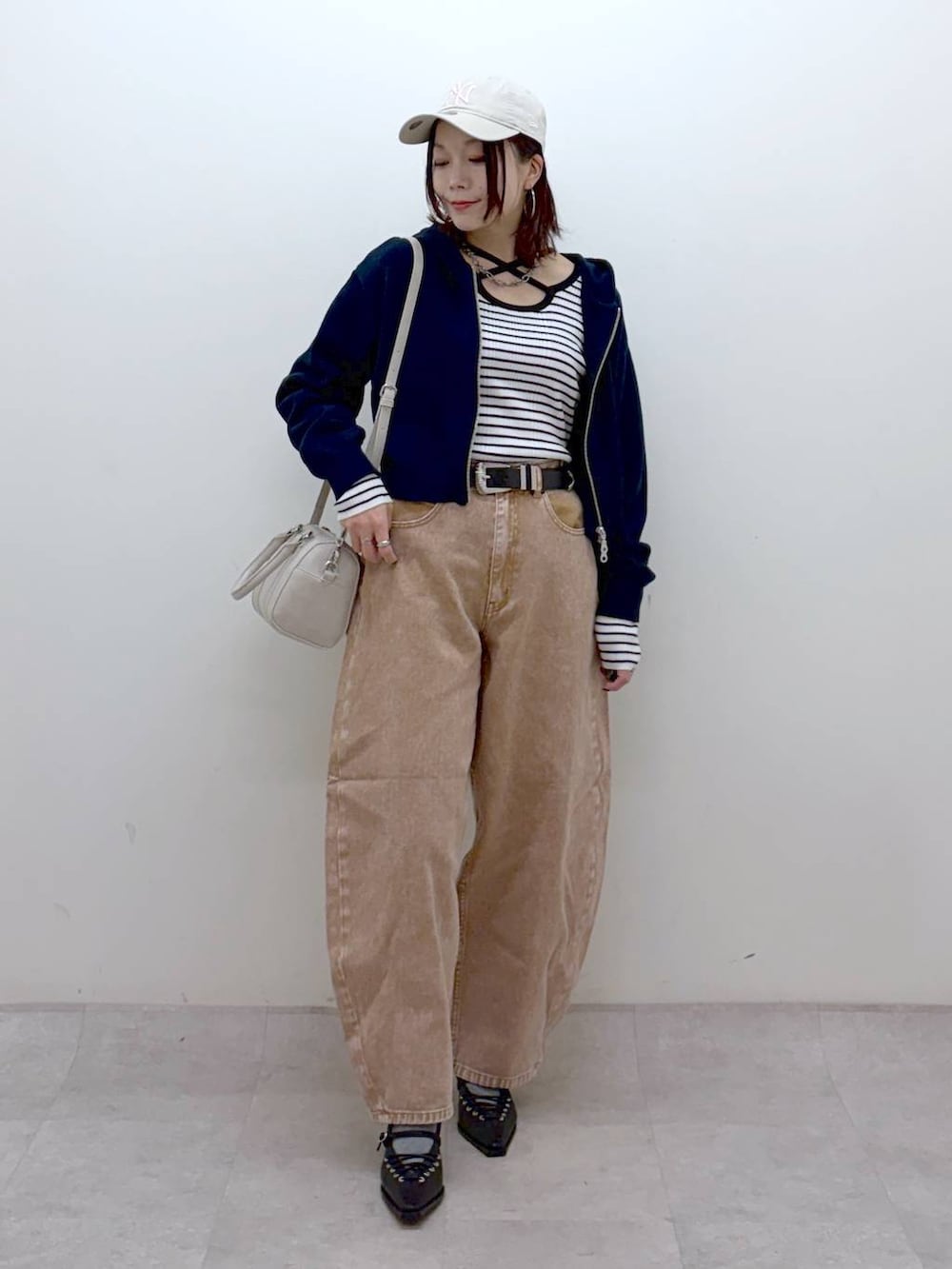 ブラウン系のデニムパンツ、ブラウン系のデニムパンツ、ホワイト系のボストンバッグを着用したレディースの冬コーディネートの9枚目の写真