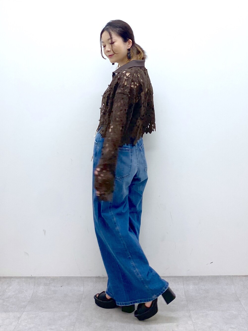 ブルー系のデニムパンツ、ブラウン系のカーディガン/ボレロ、ブラック系のキャミソールを着用したレディースの夏コーディネートの4枚目の写真