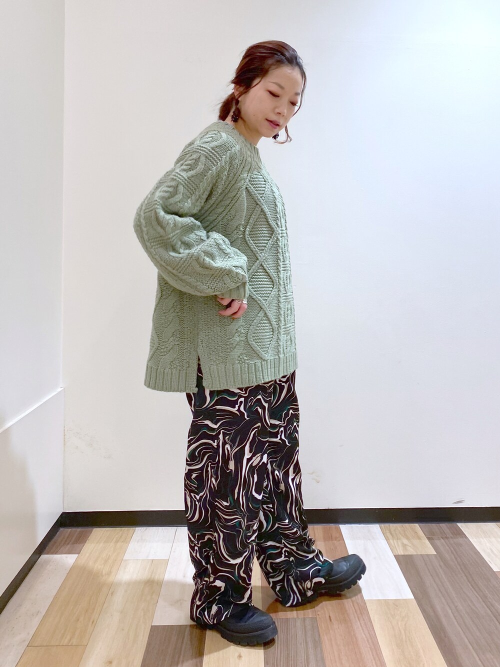 グリーン系のニット/セーター、ブラック系のその他パンツ、ブラック系のブーツを着用したレディースの冬コーディネートの5枚目の写真
