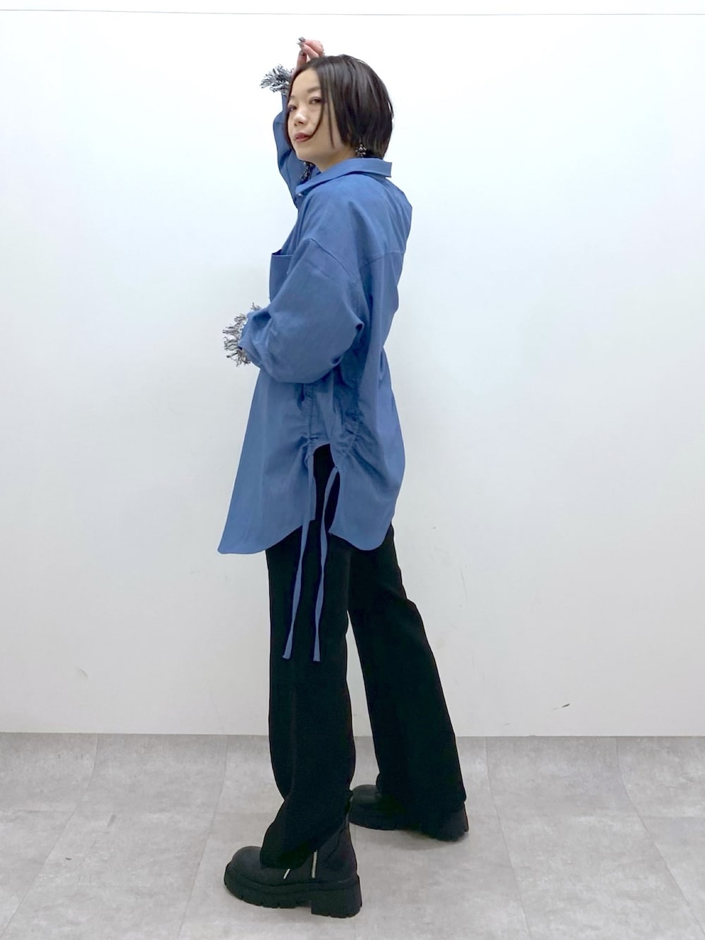 ブラック系のデニムパンツ、ブルー系のシャツ/ブラウス、ホワイト系のニット/セーターを着用したレディースの冬コーディネートの2枚目の写真