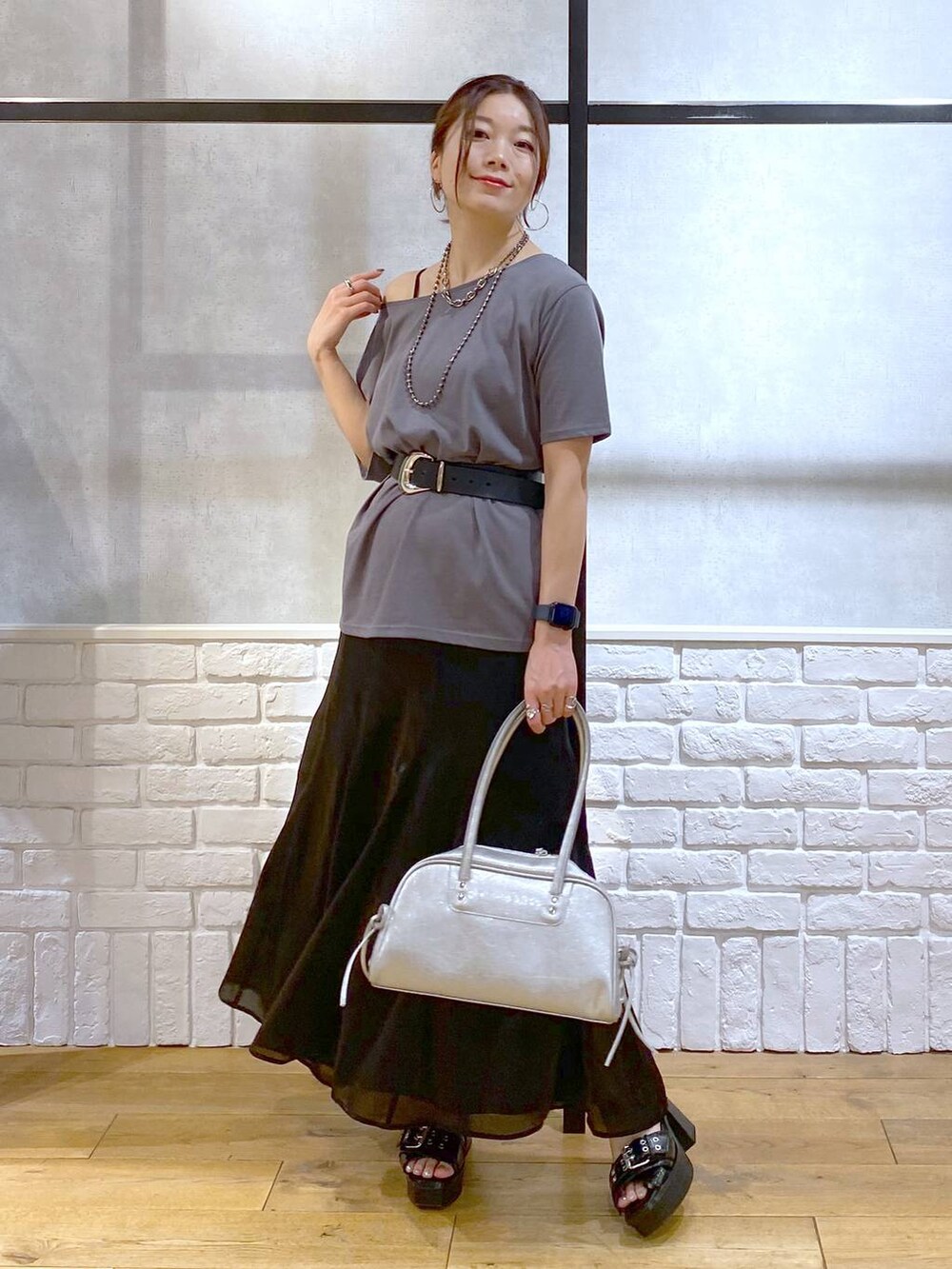 ブラック系のブーツ、シルバー系のショルダーバッグ、グレー系のTシャツ/カットソーを着用したレディースの夏コーディネートの4枚目の写真