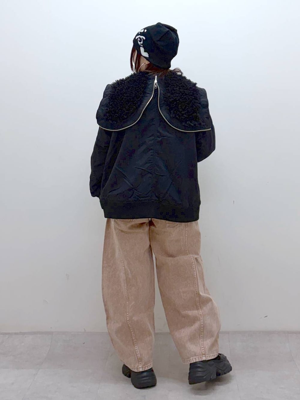 ブラック系のブーツ、ブラック系のボストンバッグ、ブラック系のブルゾンを着用したレディースの冬コーディネートの7枚目の写真