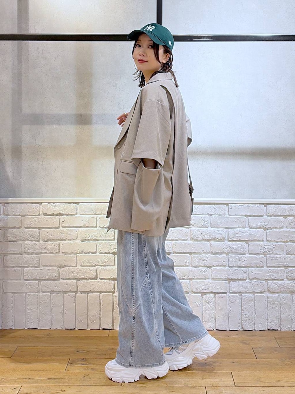 ホワイト系のスニーカー、ホワイト系のタンクトップ、ブラウン系のショルダーバッグを着用したレディースの春コーディネートの5枚目の写真