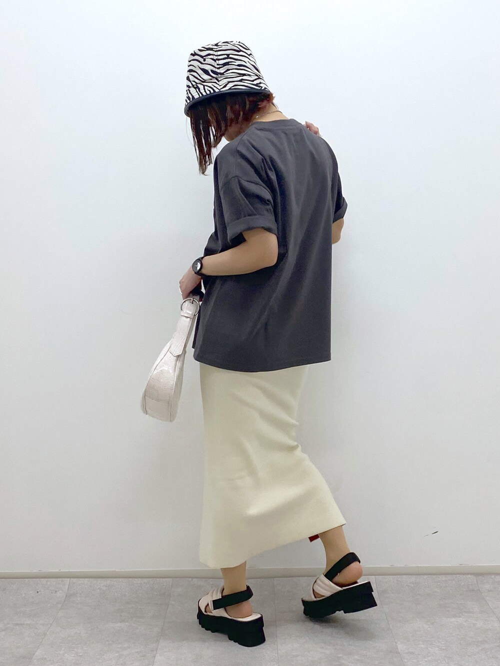 グレー系のTシャツ/カットソー、ホワイト系のショルダーバッグ、ホワイト系のスカートを着用したレディースの春コーディネートの3枚目の写真