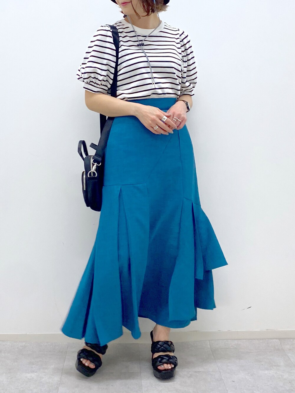 ブルー系のスカート、ブラック系のサンダル、ブラック系のショルダーバッグを着用したレディースの夏コーディネートの4枚目の写真