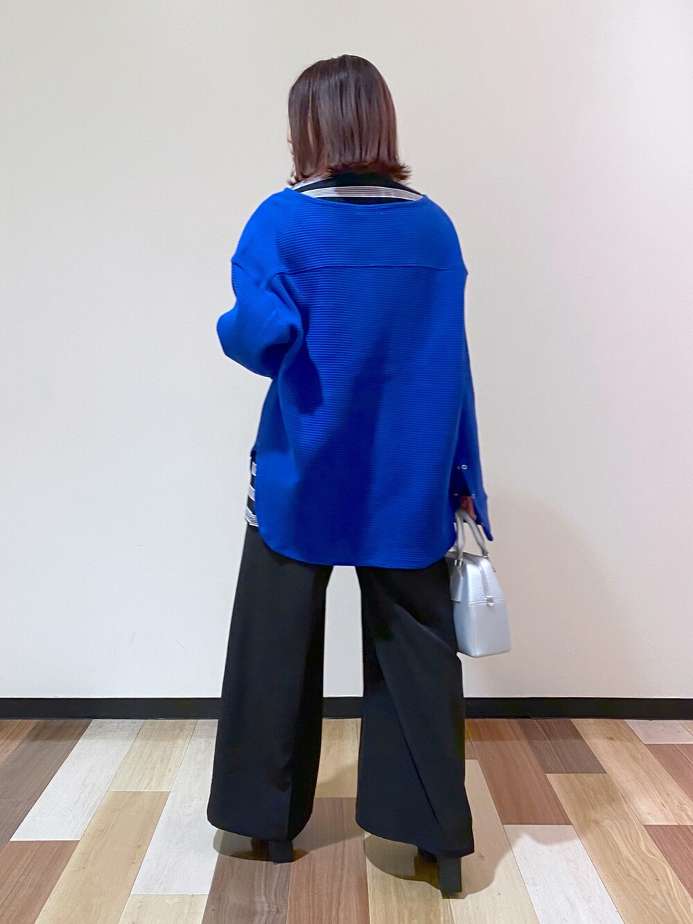 シルバー系のショルダーバッグ、ブラック系のブーツ、ブルー系のTシャツ/カットソーを着用したレディースの冬コーディネートの3枚目の写真