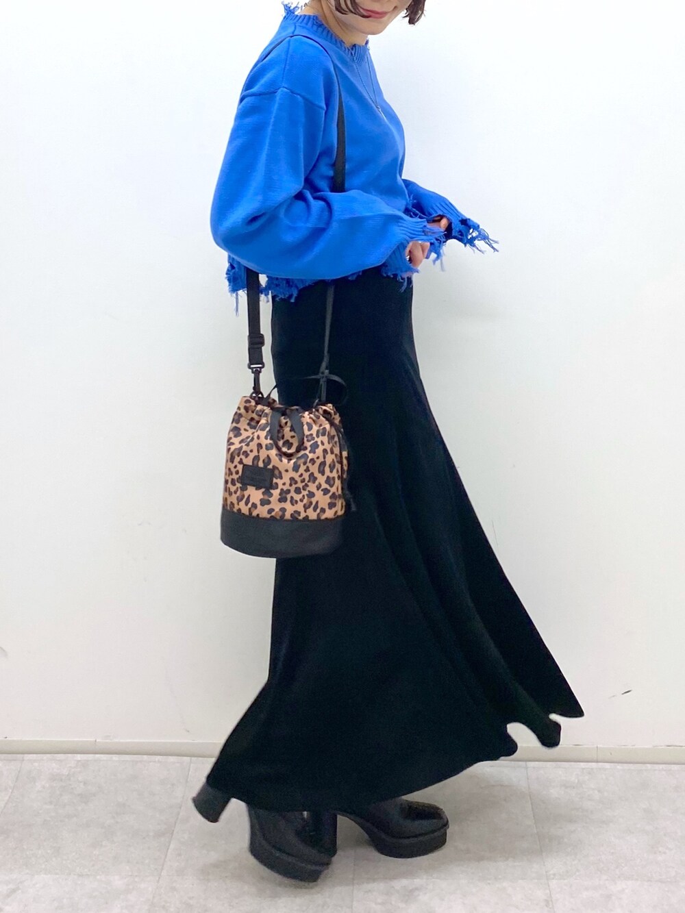 ブルー系のニット/セーター、ブラック系のスカート、その他のショルダーバッグを着用したレディースの秋コーディネートの5枚目の写真