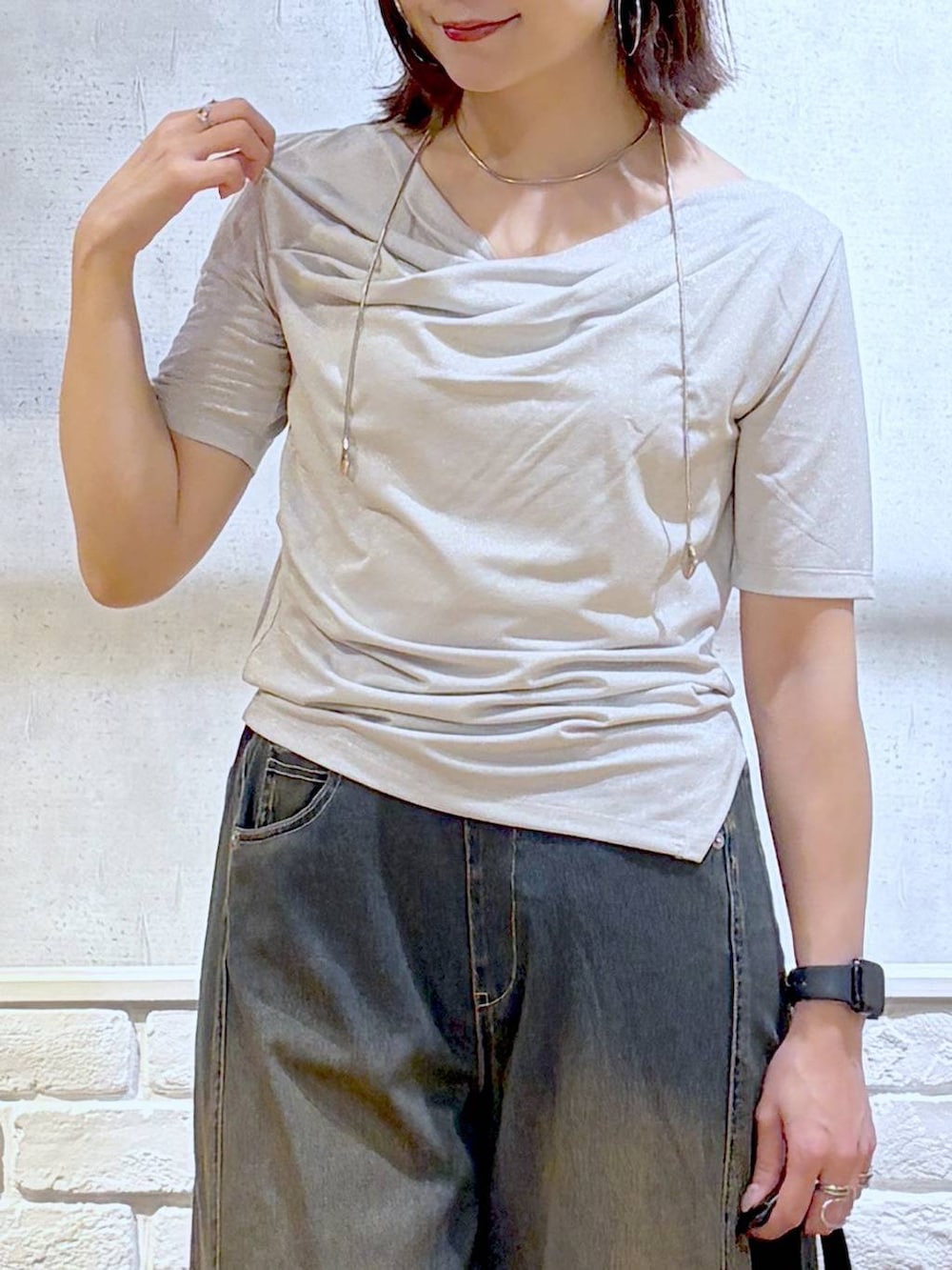 グリーン系のデニムパンツ、ブラック系のサンダル、ベージュ系のTシャツ/カットソーを着用したレディースの夏コーディネートの2枚目の写真