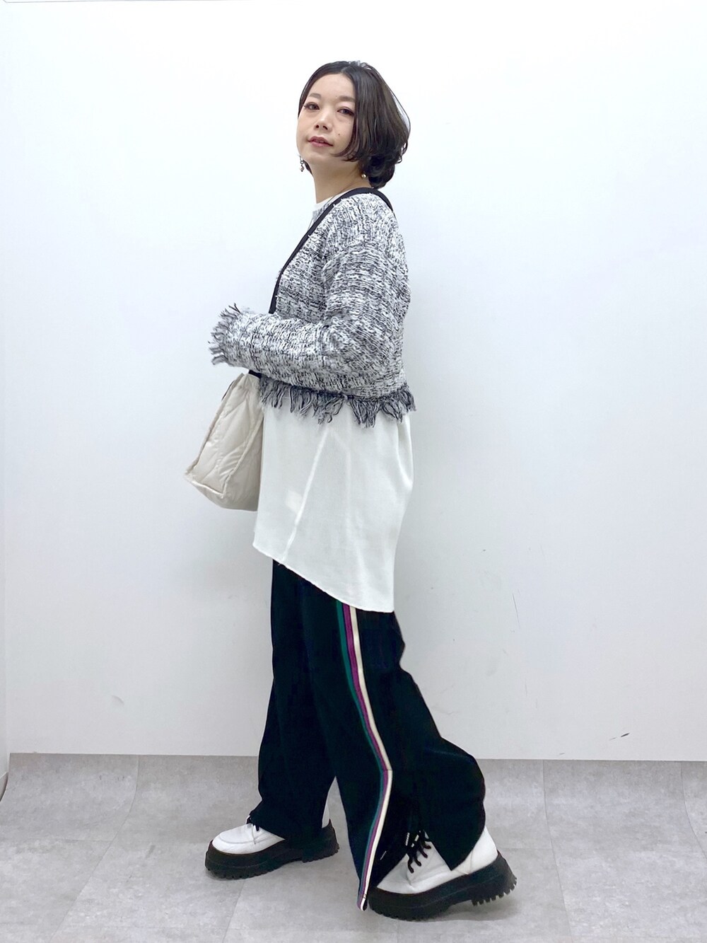 ホワイト系のニット/セーター、ブラック系のスウェットパンツ、ホワイト系のシューズを着用したレディースの春コーディネートの3枚目の写真