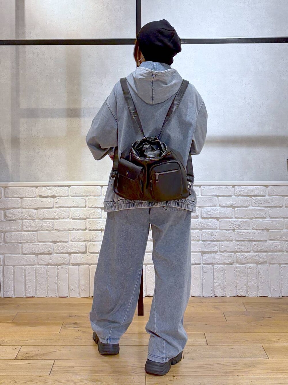 ブラック系のスニーカー、ブラック系のショルダーバッグ、ブルー系のパーカーを着用したレディースの春コーディネートの6枚目の写真