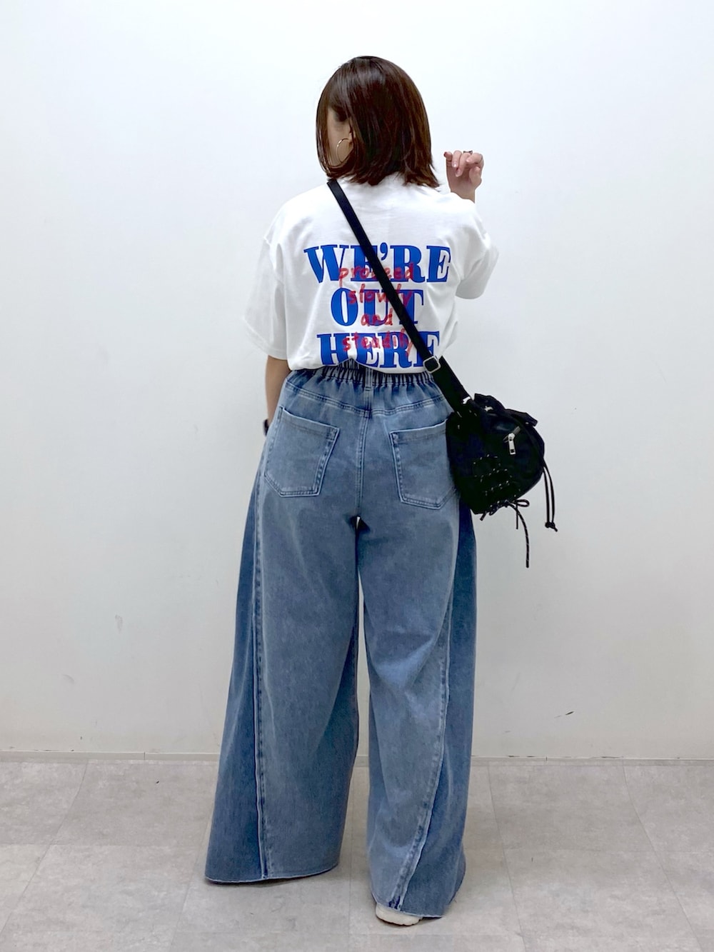 ホワイト系のTシャツ/カットソー、ブラック系のボディバッグ/ウエストポーチ、ブルー系のデニムパンツを着用したレディースの春コーディネートの7枚目の写真
