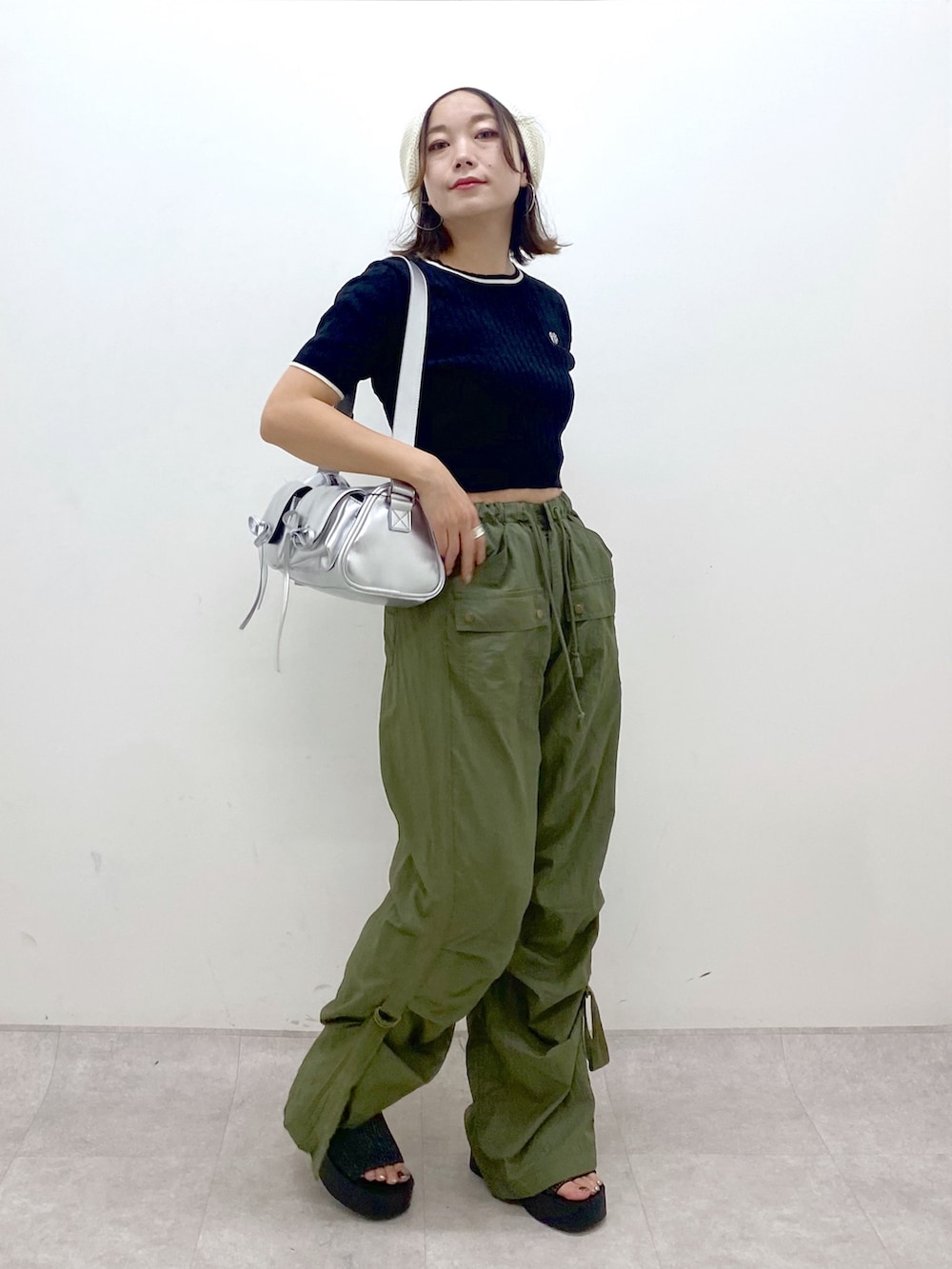 グリーン系のカーゴパンツ、ブラック系のサンダル、シルバー系のショルダーバッグを着用したレディースの夏コーディネートの8枚目の写真