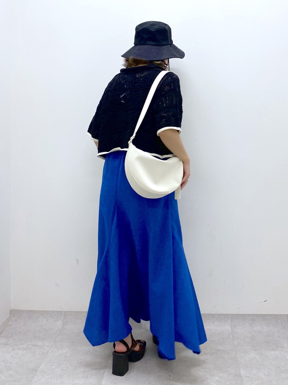 ブルー系のスカート、ホワイト系のショルダーバッグ、その他のサンダルを着用したレディースの夏コーディネートの4枚目の写真
