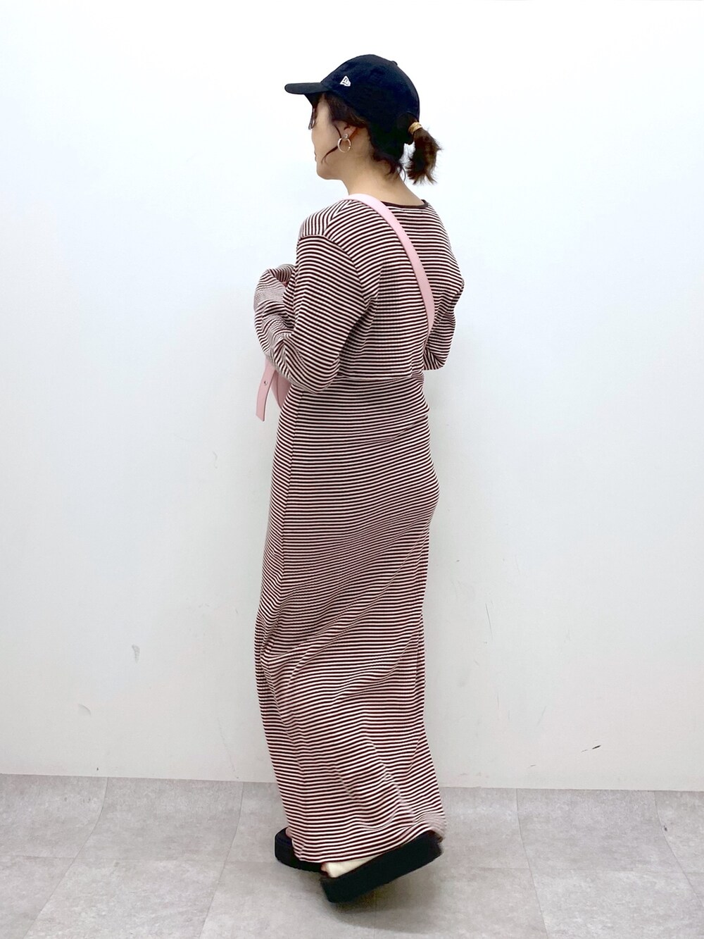 ブラウン系のワンピース、ピンク系のショルダーバッグ、ホワイト系のサンダルを着用したレディースの春コーディネートの3枚目の写真