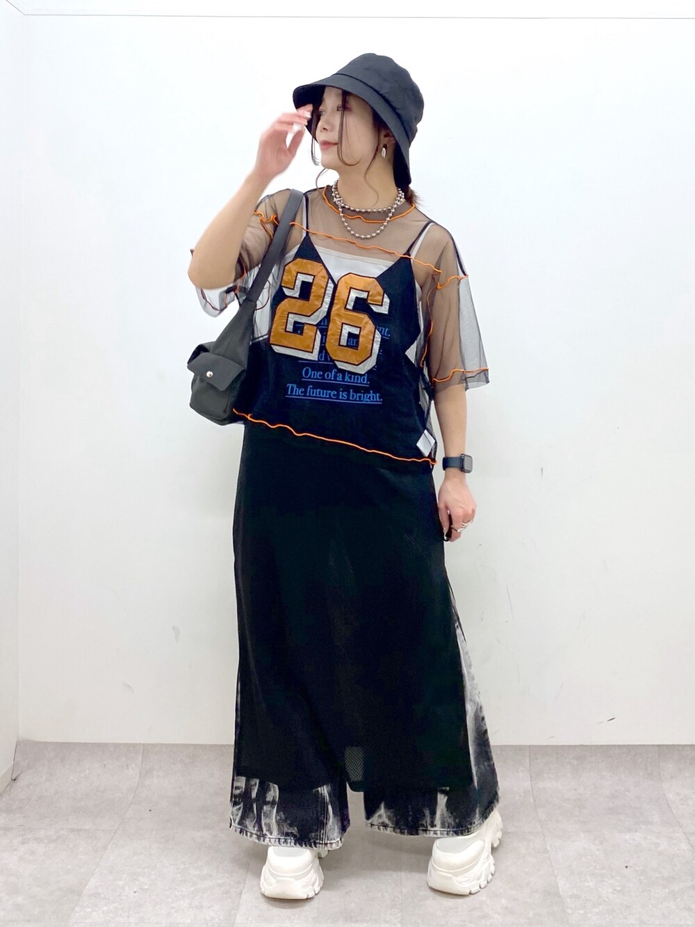 グレー系のショルダーバッグ、ホワイト系のスニーカー、ブラック系のデニムパンツを着用したレディースの春コーディネートの8枚目の写真