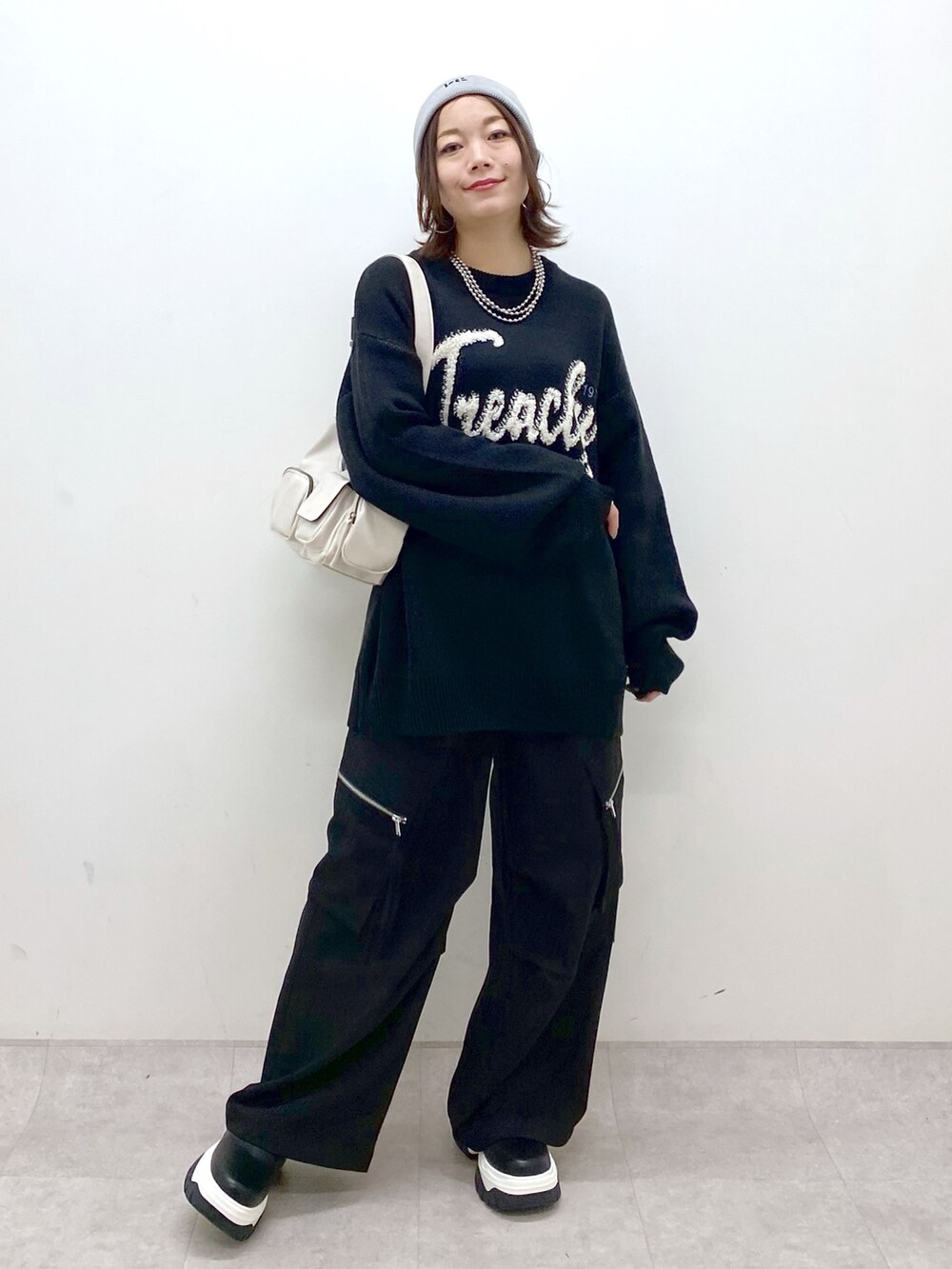 ブラック系のニット/セーター、ブラック系のカーゴパンツ、ホワイト系のショルダーバッグを着用したレディースの冬コーディネートの8枚目の写真
