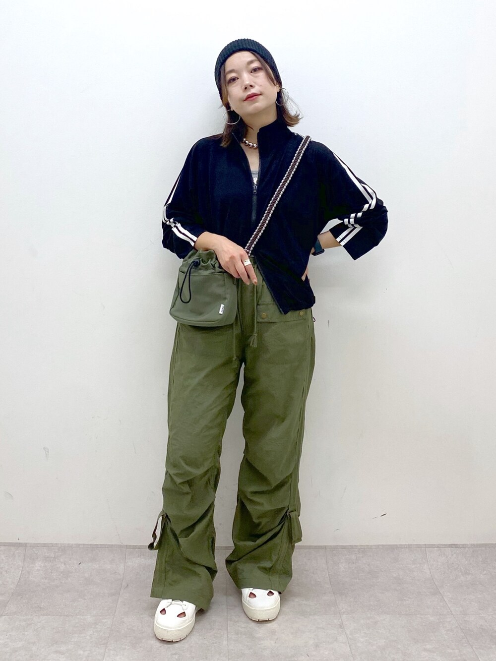 グリーン系のカーゴパンツ、ホワイト系のスニーカー、グリーン系のショルダーバッグを着用したレディースの夏コーディネートの4枚目の写真