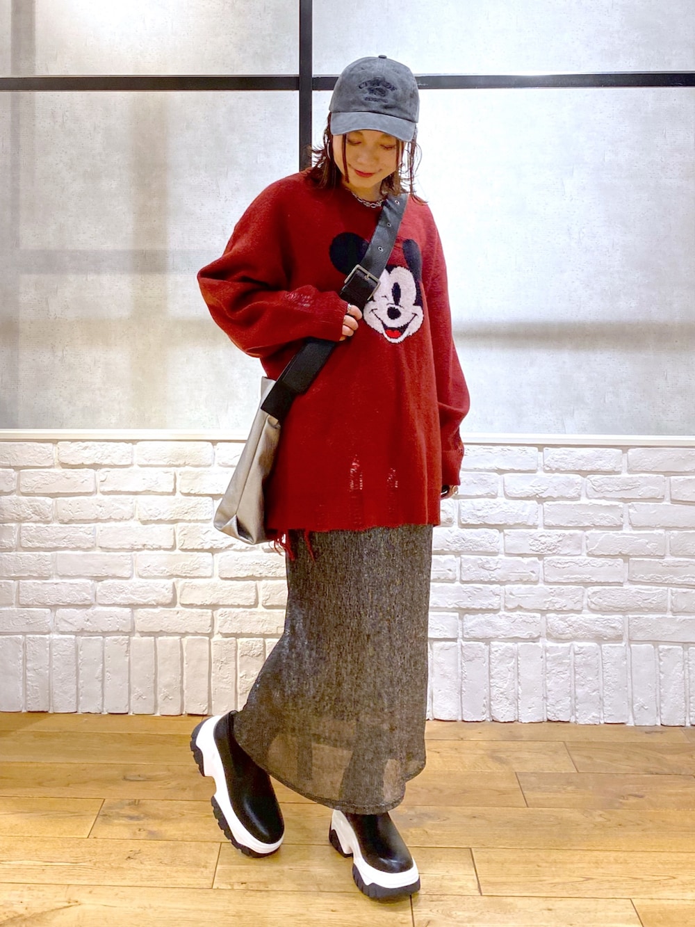 ブラック系のスカート、ブラック系のブーツ、シルバー系のトートバッグを着用したレディースの冬コーディネートの8枚目の写真