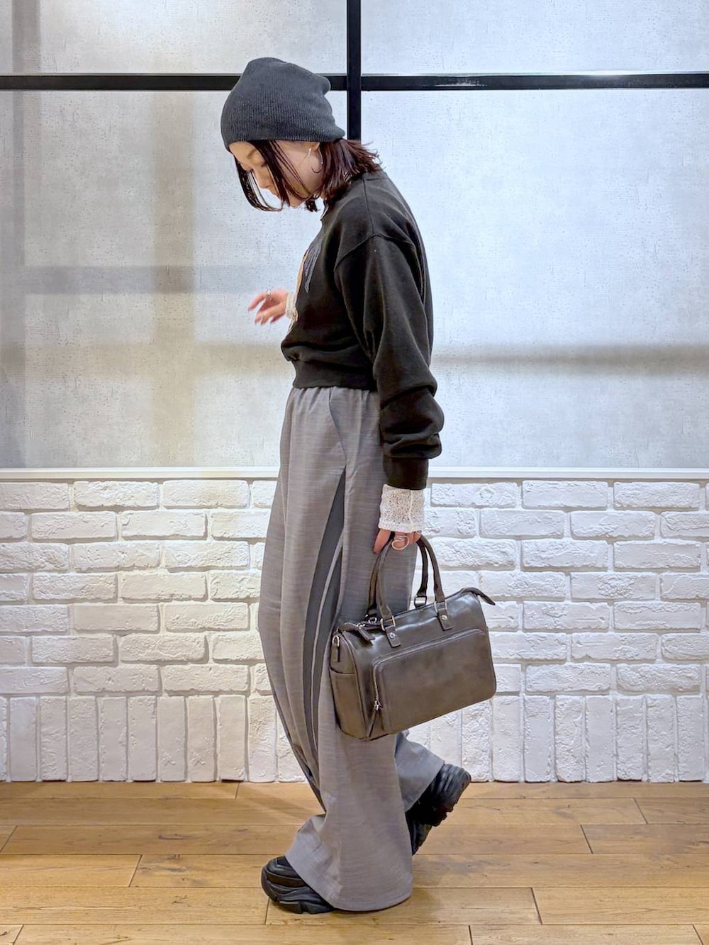 ブラック系のスニーカー、グレー系のスウェット、ブラック系のショルダーバッグを着用したレディースの冬コーディネートの7枚目の写真