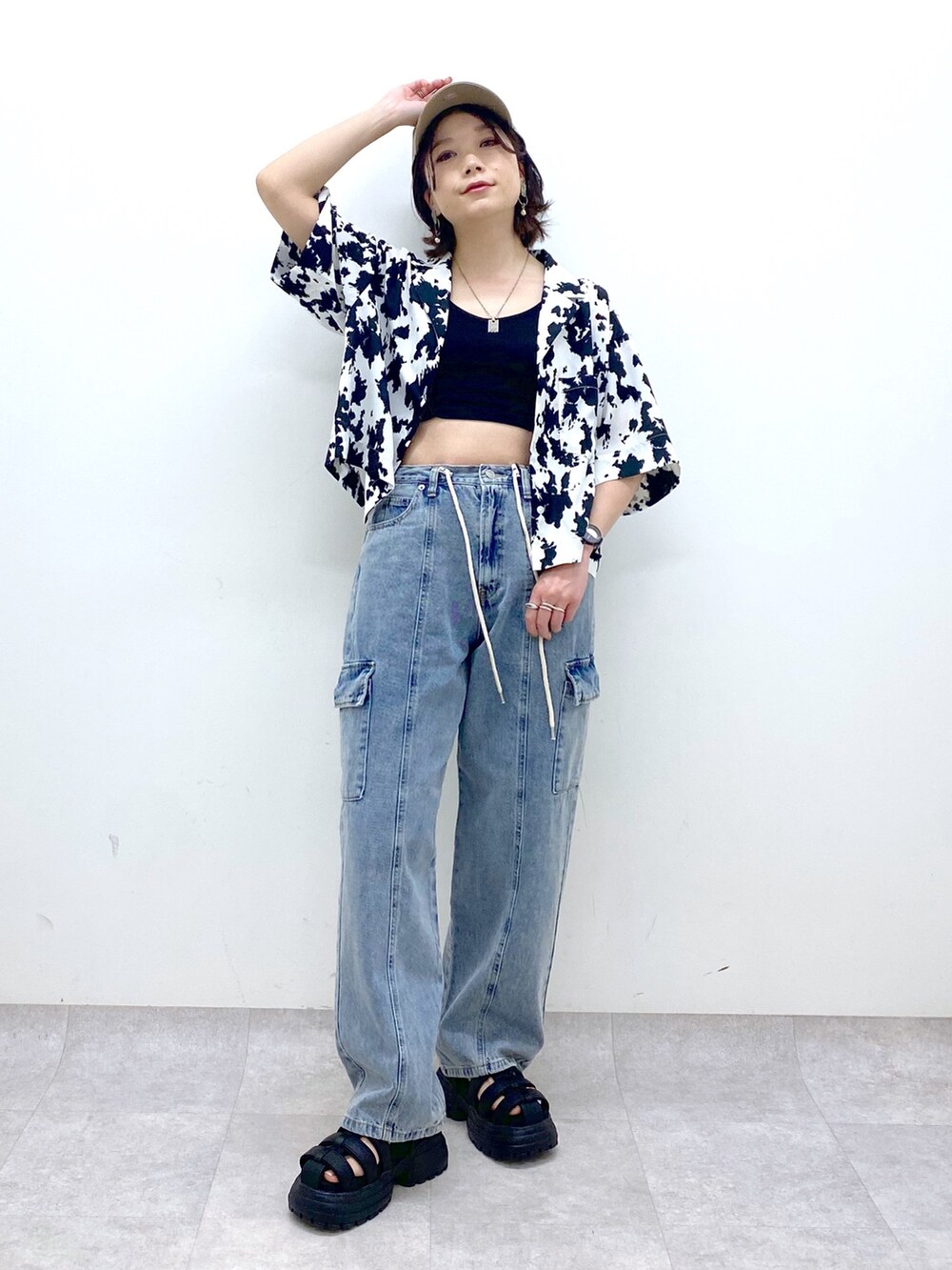 ブルー系のデニムパンツ、ブラック系のサンダル、ブラック系のトップスを着用したレディースの春コーディネートの5枚目の写真